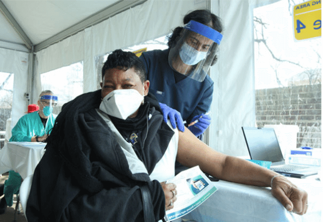 Patient receiving a vaccine at an outdoor clinic