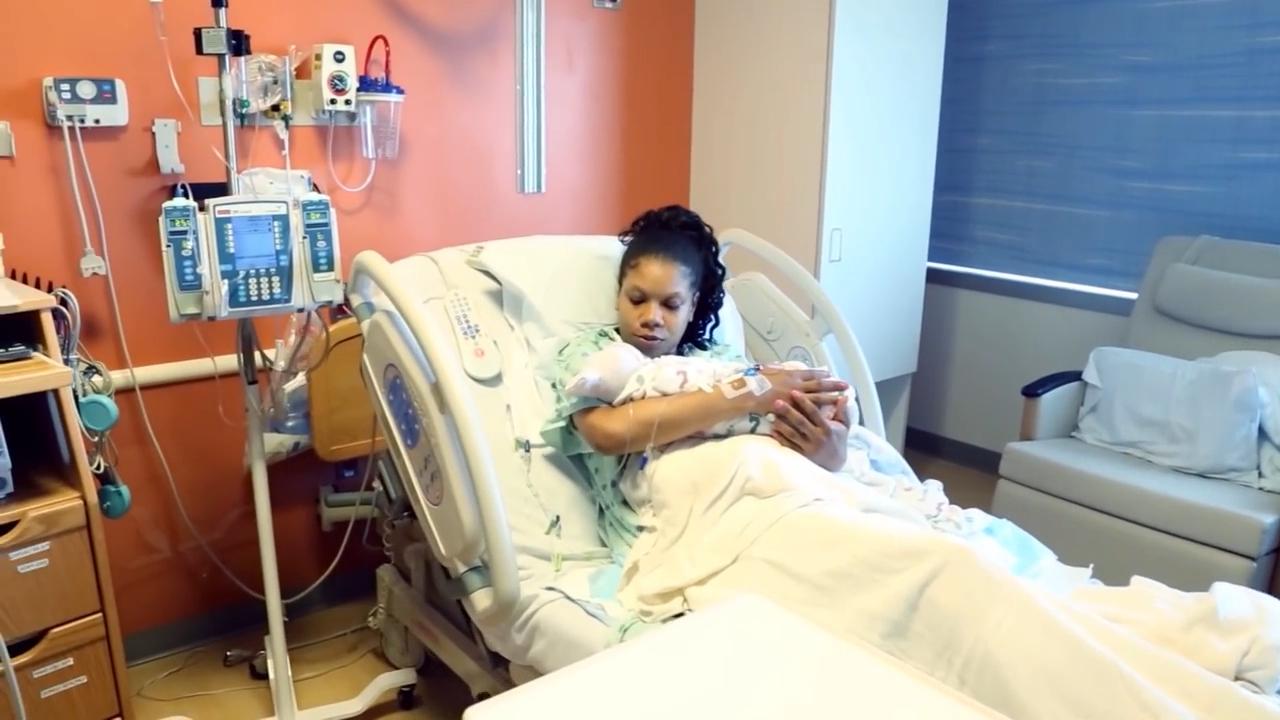 Mom holding newborn baby in postpartum room at Johns Hopkins Hospital