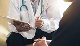 colorectal cancer - doctor talking to patient holding clipboard and pen