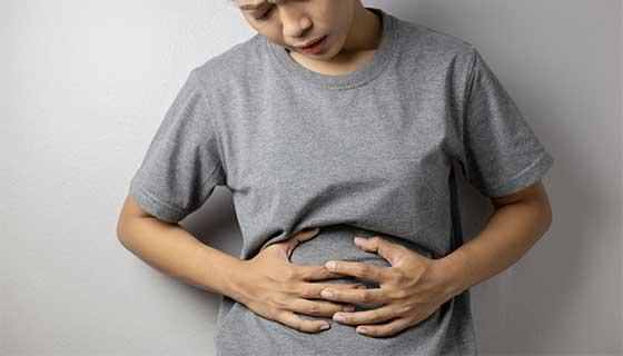 Woman holding her stomach in pain.