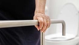 Old woman holding onto a safety rail