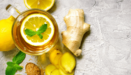 Ginger tea next to ginger power and ginger root on a table