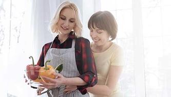 A lesbian couple cooks together.