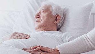 man in bed with a woman's hand holding his