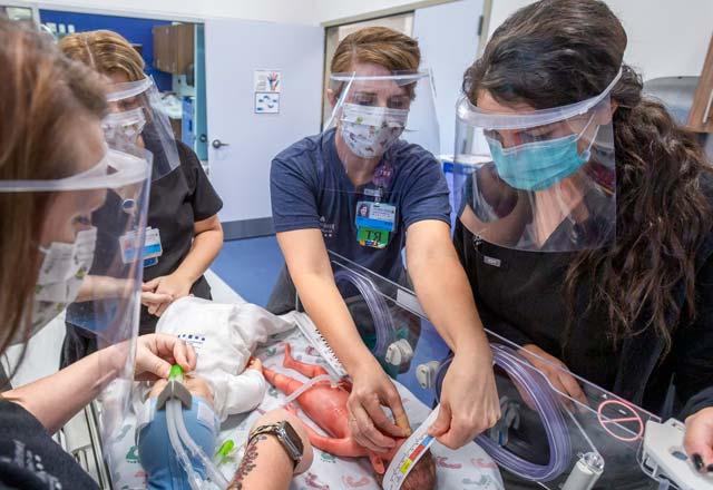 A group of nurses running a scenario in the simulation lab