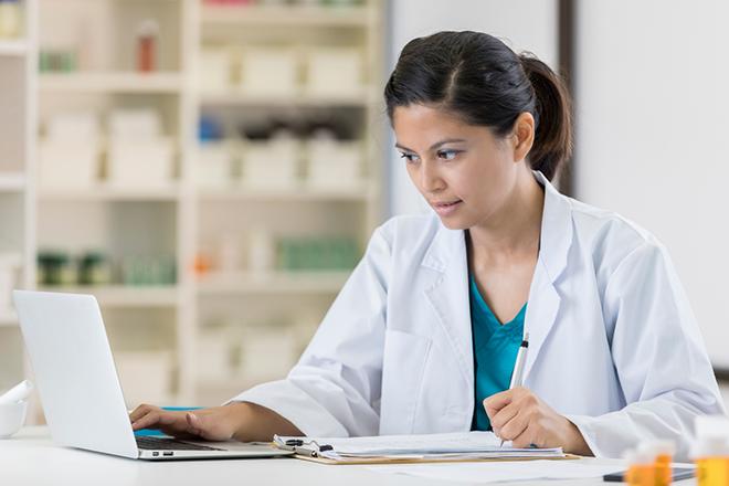 Healthcare professional taking notes at a desk