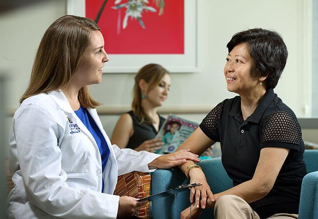 doctor speaks to patient in waiting area