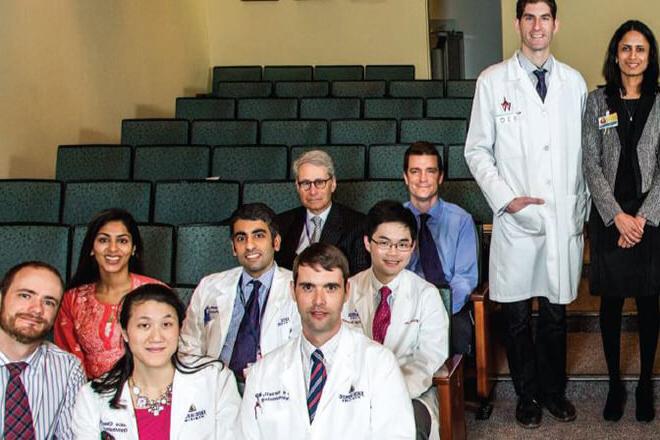 A group of doctors and students inside of a lecture room.