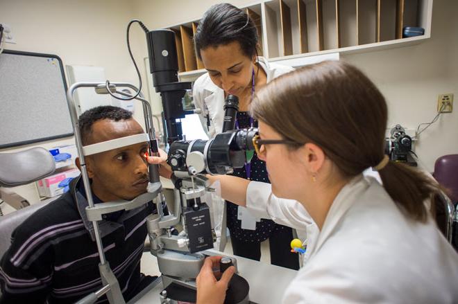 A resident works with a patient in the ophthalmology clinic